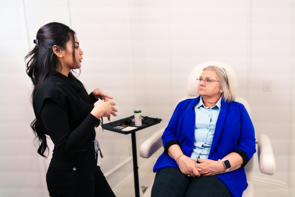 Practitioner in consultation with a seated client in a clinic