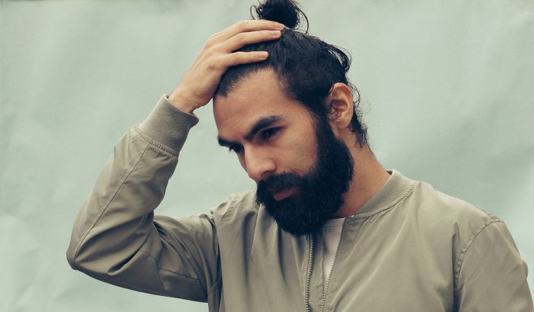 Man running his hand through his hair, checking his hairline