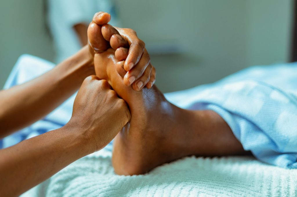 Hands caring for a foot with massage oil