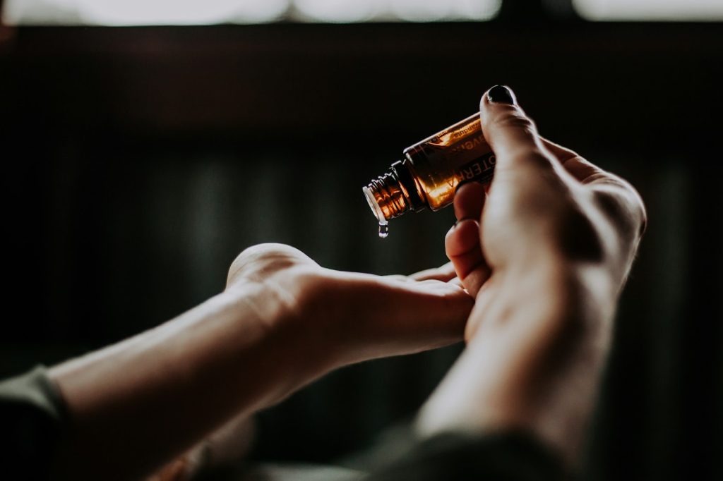 Amber dropper bottle of hair serum held in the hands