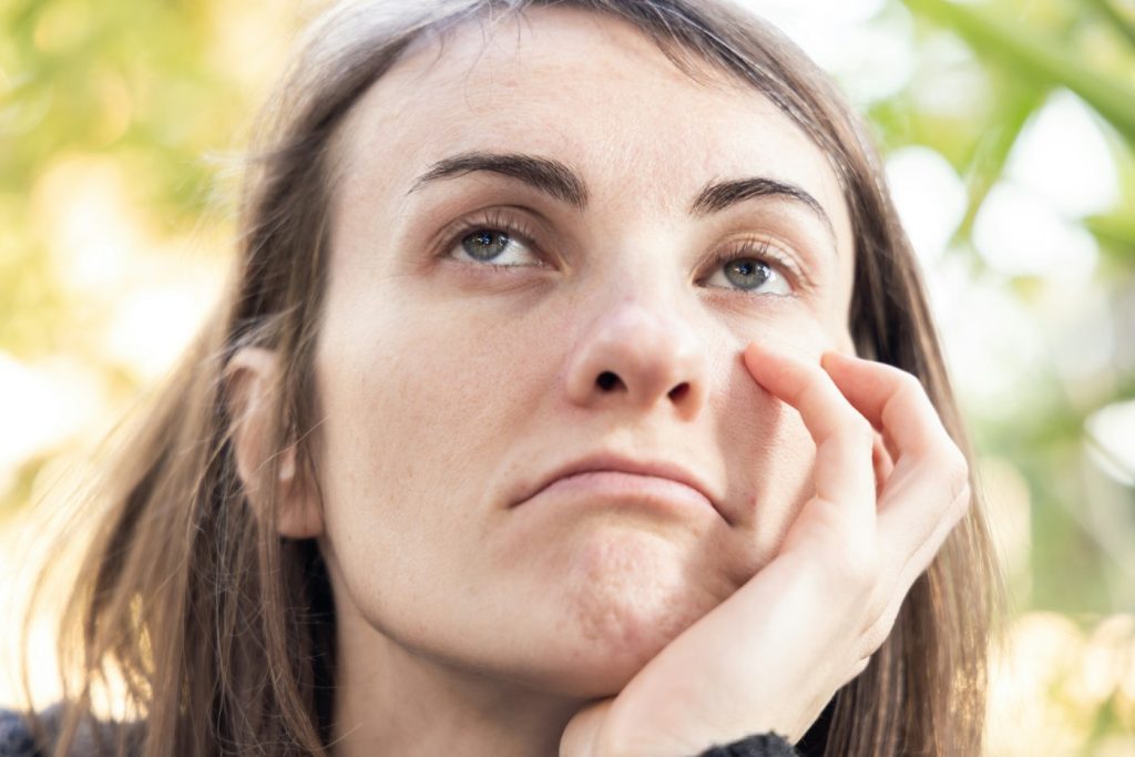 Woman resting her chin on her hand, looking thoughtful