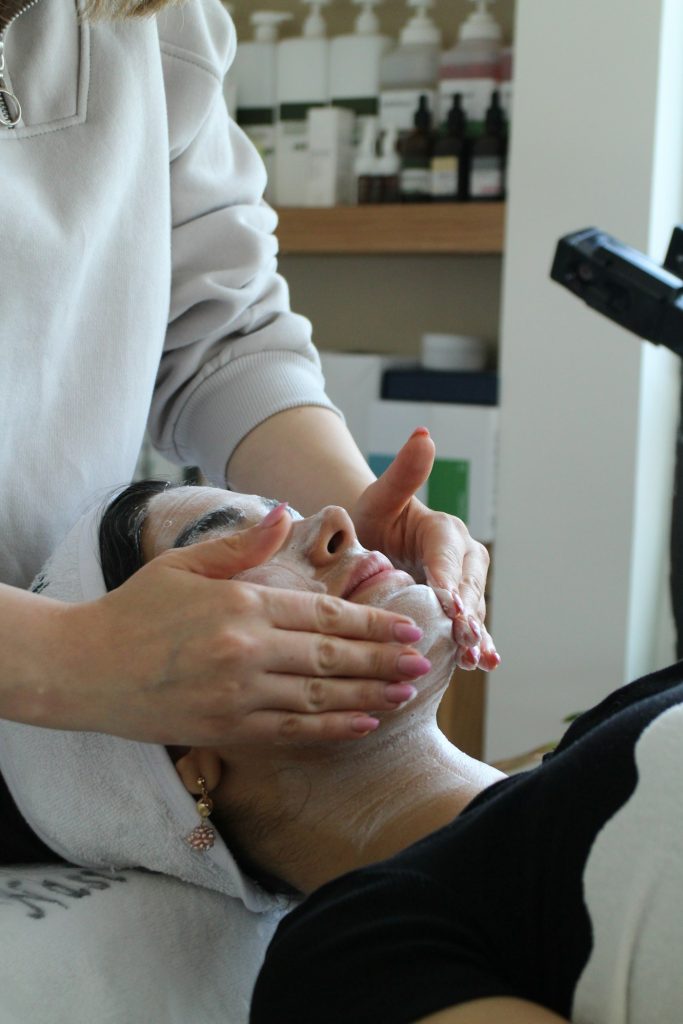 Hands massaging a client's face during a facial